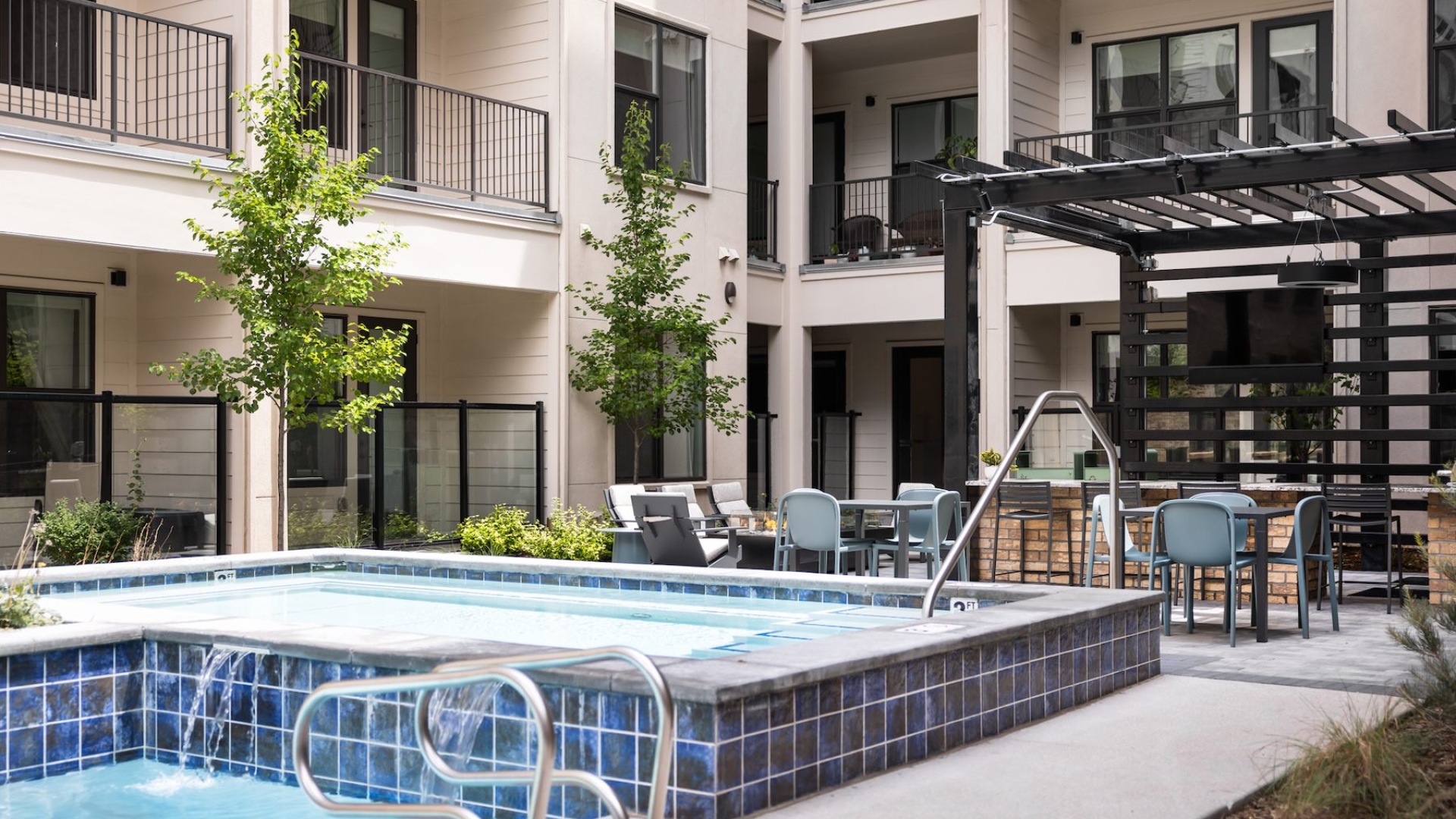 a courtyard with a swimming pool, fire pit and bar area