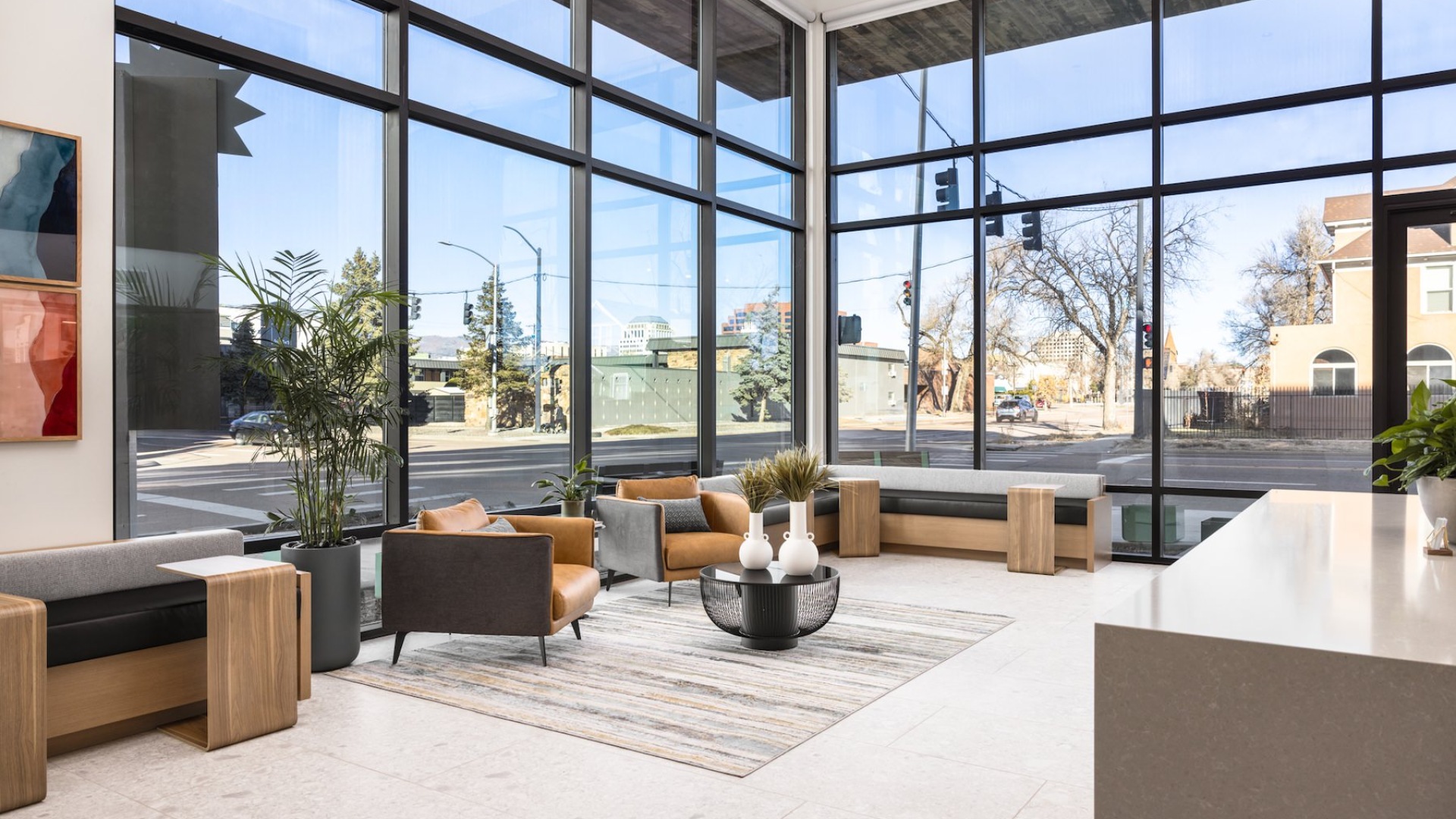 a room with floor to ceiling windows with booth seating and chairs