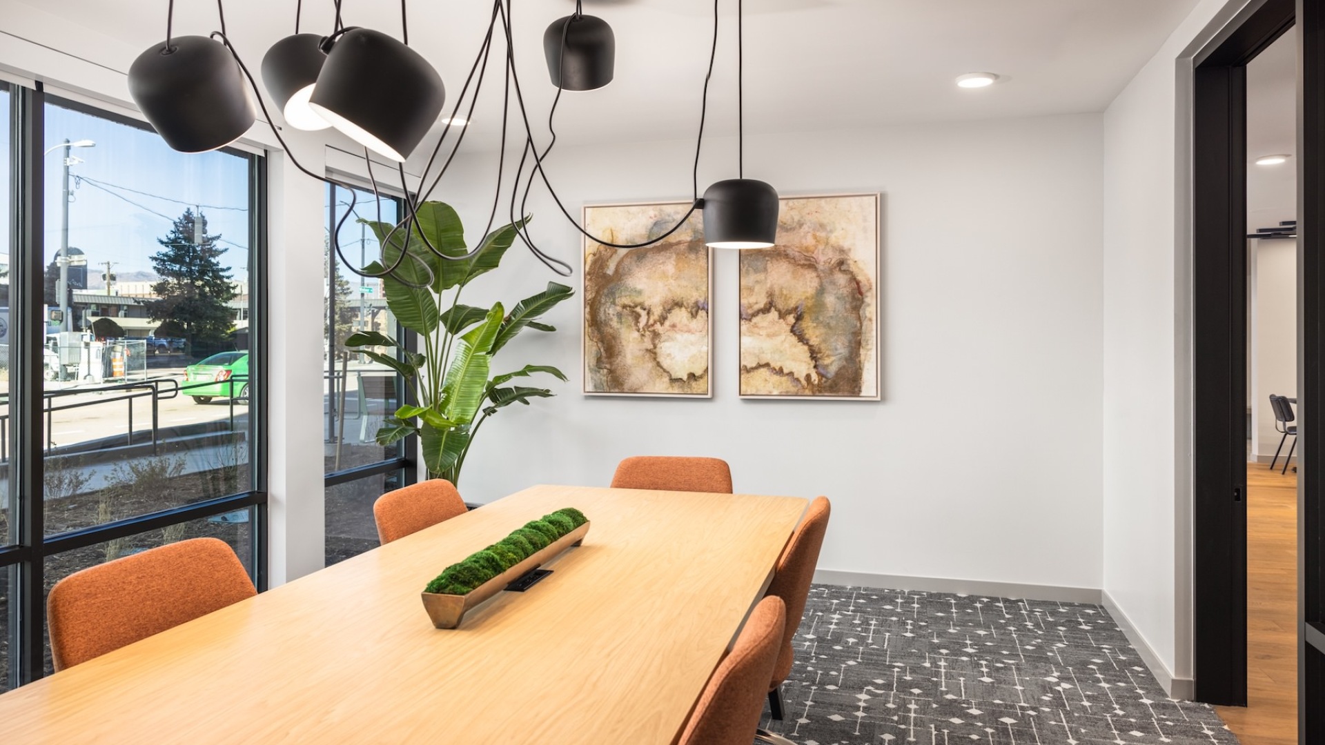 a room with large windows and a conference table and chairs
