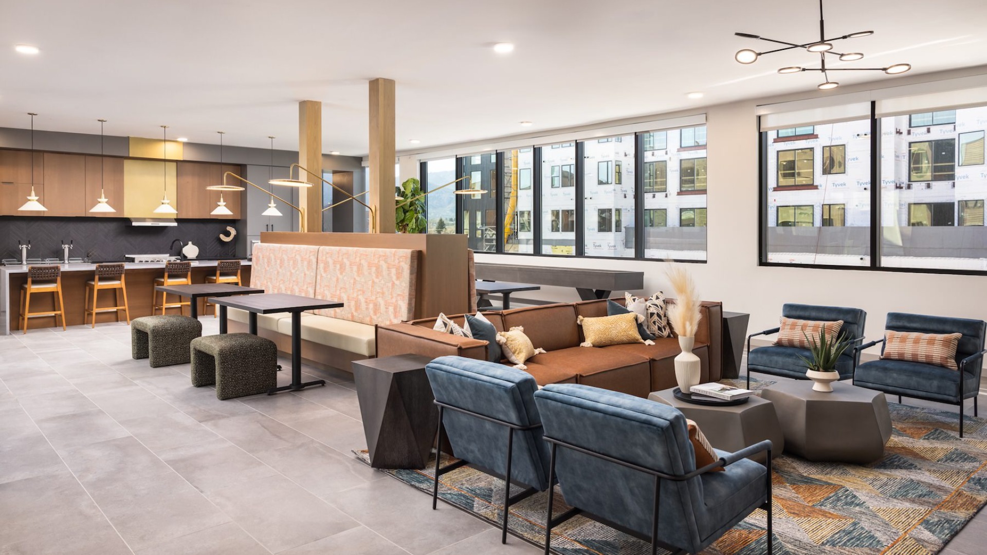 a room with a seating area, billiard table, and kitchen with bar stool seating