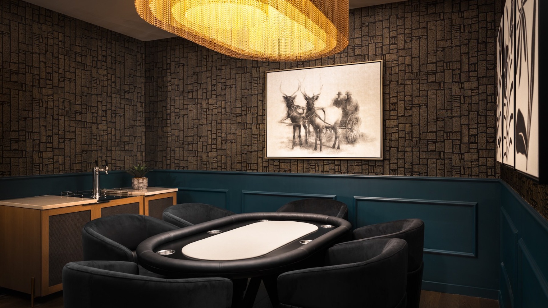a dark room with a gaming table, chairs and art on the wall