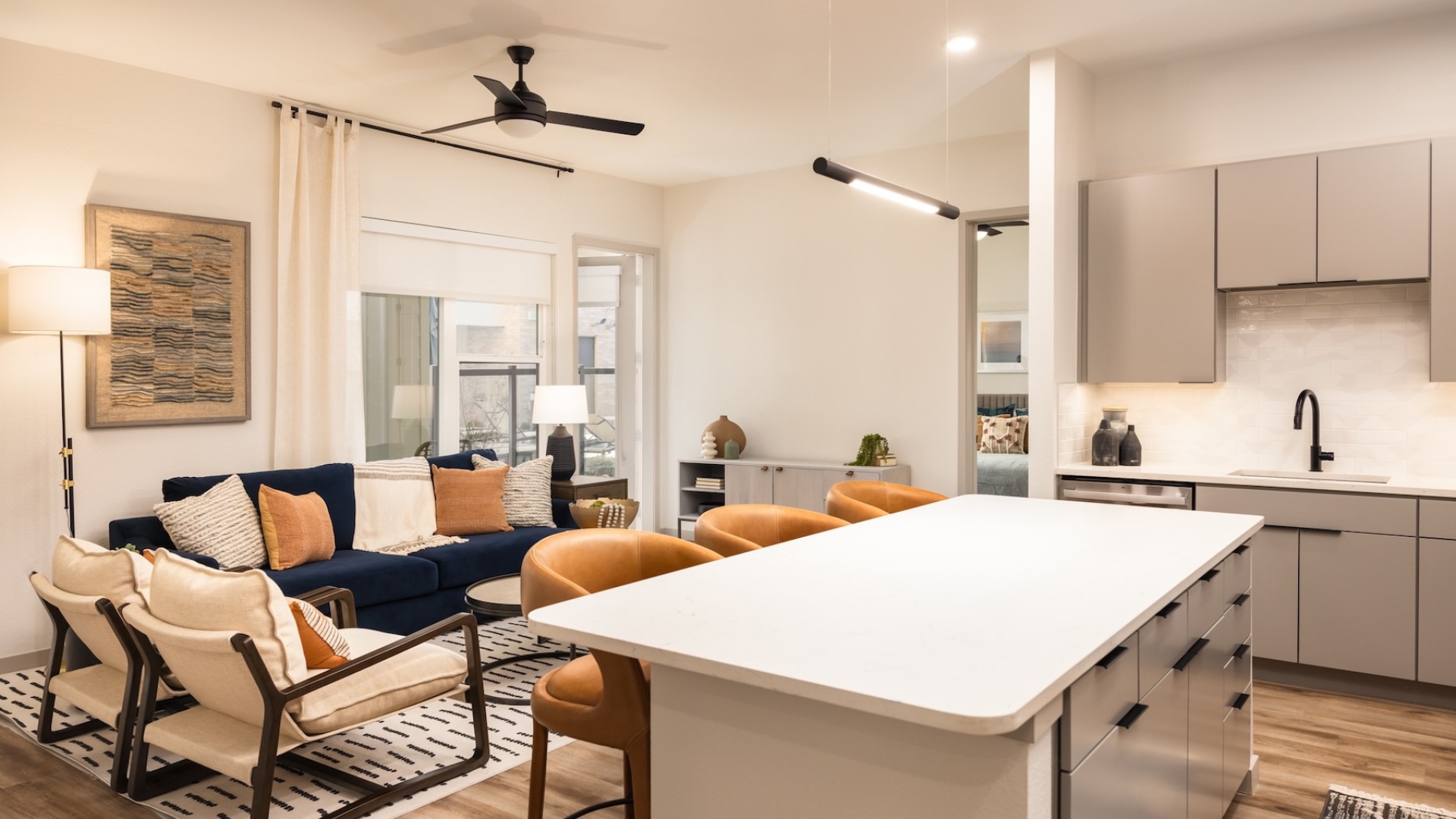 kitchen with white counters and living area with chairs and a couch