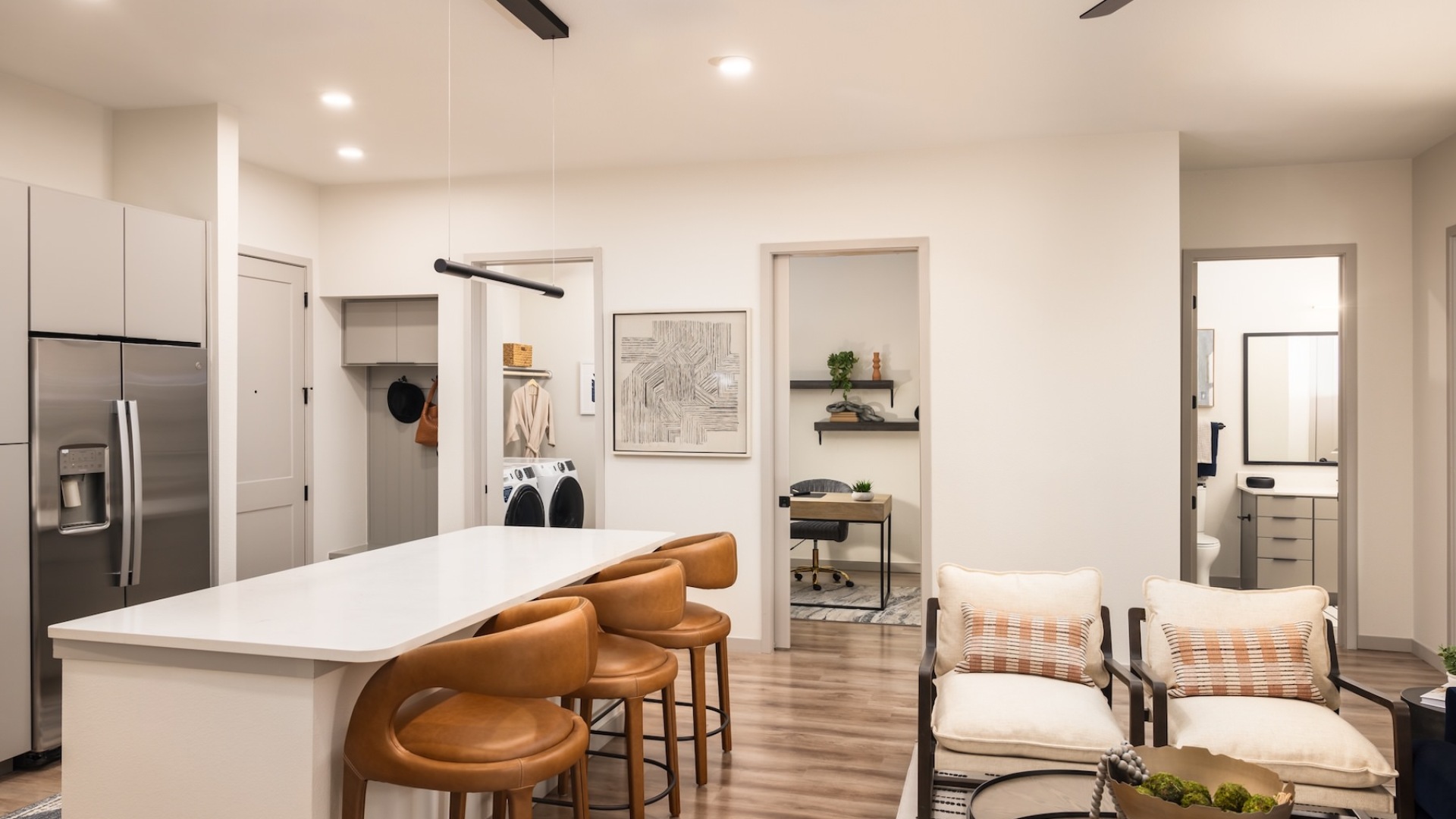 kitchen with an island and stainless steel appliances and living area with chairs