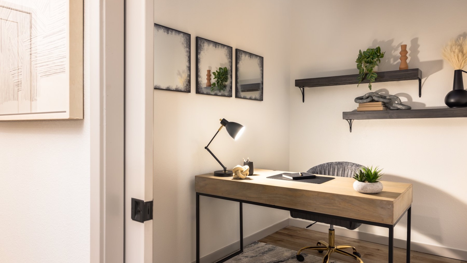 a room with art on the walls and a desk and chair